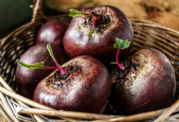Fresh organic beets. Beets in a basket on a wooden table. The concept of rural life and healthy nutrition.
