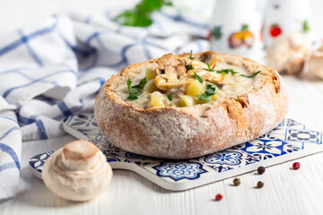 Potato-mushroom soup in a loaf of bread. - obrazy, fototapety, plakaty