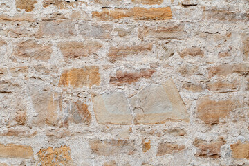 Masonry of old ancient wall close-up of uneven stones