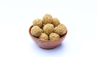 Indian sweet sesame laddu or til laddu in a wooden bowl on white background 