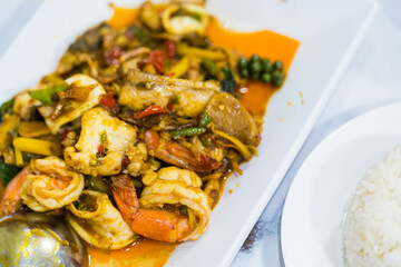 Stir fried spicy and delicious seafood on a white dish