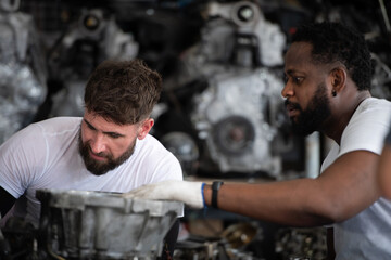 Two men repairing car engine in auto repair shop, Selective focus.