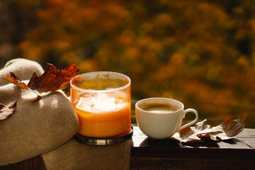 Sweet Home. Still life details in home on a wooden window. Sweater, candle, hot coffee and autumn decor. Autumn home decor. Cozy fall mood. Cozy autumn or winter concept.