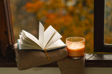 Sweet Home. Still life details in home on a wooden window. Sweater, candle and autumn decor. Autumn...