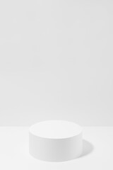 Abstract one white round podium for cosmetic products in hard light, mockup on white background, vertical. Scene for presentation products, gifts, goods, advertising, design, sale, display, showing.