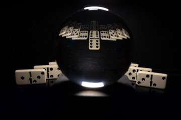 Dominos with reflections and glass ball dark background 