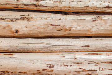 Logs of wood round, hewn, processed, stacked close-up