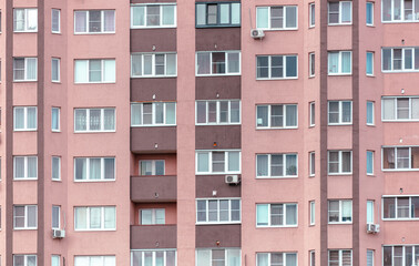 Fototapeta na wymiar Walls with windows of a multi-story building as a background