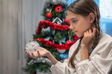 Close-up view of a beautiful girl with romantic braids and a vintage shirt, in a Christmas mood...