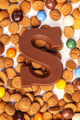 Dutch holiday Sinterklaas background with chocolate letter, kruidnoten cookies and traditional hollands sweets.