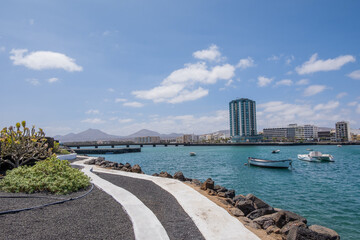 View of the city of Arrecife from the Fermina islet. Turquoise blue water. Sky with big white clouds. Seascape. Lanzarote, Canary Islands, Spain.