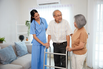 nurse or caregiver helping senior man walking with a walker and senior woman support him at home