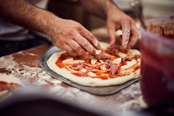 Obraz na płótnie Canvas Man making delicious pizza Napoletana, putting a cheese on the top.