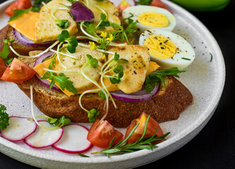 toast with chicken breast, onion and vegetables on a white plate close up