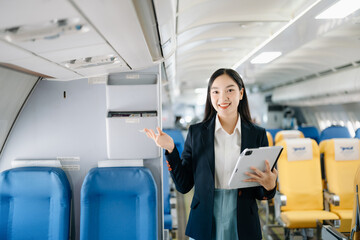 Asian executive excels in first class, multitasking with digital tablet, laptop. Travel in style,...