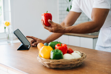 Man hands preparing a healthy salad. Cutting vegetables tomatoes on a cutting board