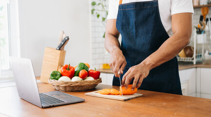 Man hands preparing a healthy salad. Cutting vegetables tomatoes on a cutting board