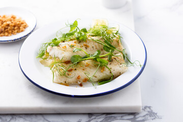 Baked white fish filet with green pea and lime