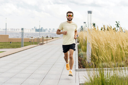 Fitness trainer cardio training daily. Young man exercise warm-up running in a sports T-shirt.