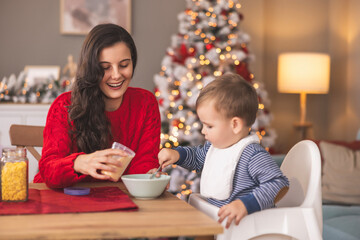 Mother and baby having breakfast on Christmas morning at home