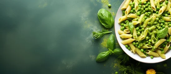 Fotobehang Italian food featuring penne pasta pesto sauce zucchini green peas and basil photographed from above in a flat lay style Copy space image Place for adding text or design © Ilgun