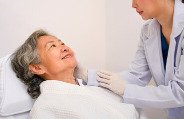 Fototapeta premium asian senior woman smile when cosmetologist touching her face to check her facial skin condition for cosmetic treatment at aesthetic clinic