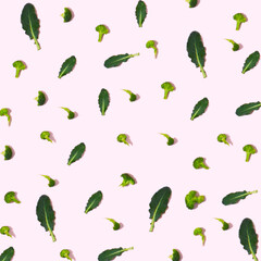 Pattern made of broccoli and leaves on pink background. Creative food concept.