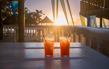Red straw drinks at sunset in a tropical paradise in Jamaica
