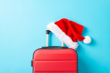 Santa's on the move, making a stop at your party! Top view picture showcasing a red suitcase,...