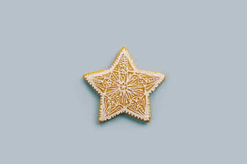 Christmas gingerbread snowflake with white glaze ornament on a blue background
