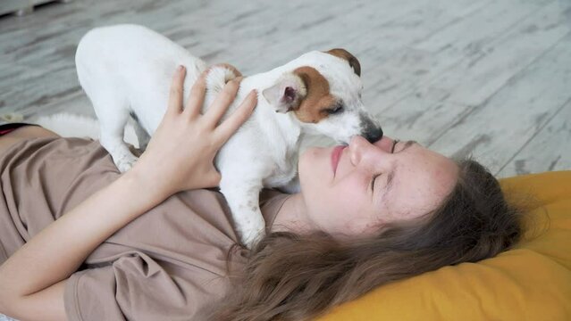 Teen girl playing with puppy dog at home