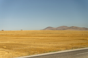 Deserted fields and mountains in the background, isolated houses in the distance, a view from the...