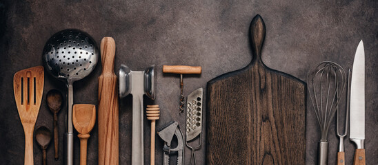 Various kitchen utensils and tools on a brown rustic background, banner. Top view, flat lay....