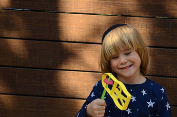 Cute boy in a kippah with a rattle. Kid and Aleintref. Raashan in the hands of a child - Jewish holiday Purim