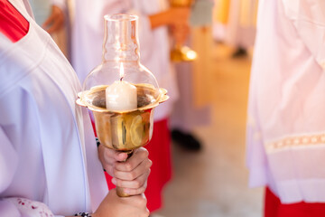Woman wearing a white Catholic clerical robe holds a candle to pay respects to God.praying to ask for a blessing from God. Christmas - obrazy, fototapety, plakaty