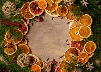 Fototapeta na wymiar Christmas nature arrangement with dried orange pieces, cinnamon sticks, pine cones, star anise and Christmas tree branches