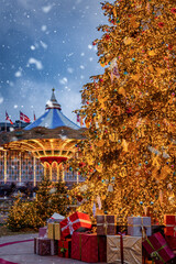 Christmas in Copenhagen, Tivoli Gardens, with a decorated tree, in front of a spinning Carousel,...