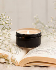 VELA EM CENARIO DELICADO FLORES E LIVRO