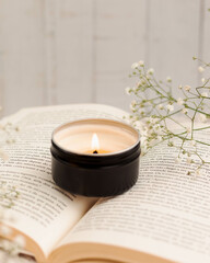 VELA EM CENARIO DELICADO FLORES E LIVRO