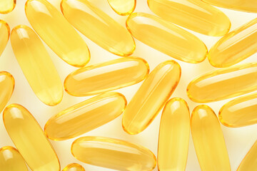 Capsules. Yellow pills isolated on white. Close up capsules with Vitamin D, E or Omega 3,6,9 fatty...