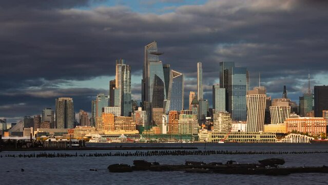 New York City time lapse of Manhattan West skyline with Hudson Yards skyscrapers. View from across Hudson River with passing clouds at sunset