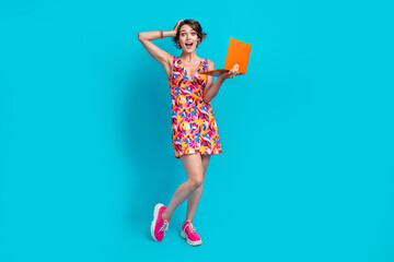 Full length photo of excited funky girl dressed print outfit online education modern gadget isolated blue color background