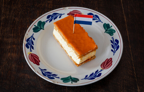 Orange variant of tompouce with dutch flag. Traditional dutch pastry eaten around King's Day national holiday