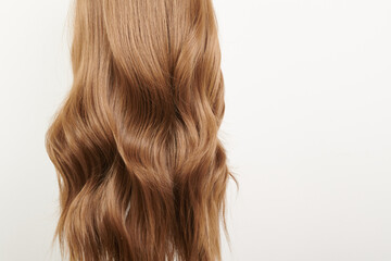 Naklejka premium Natural looking shiny hair, brown curls isolated on white background with copy space