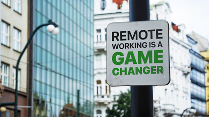 Remote working is a game changer written on a sign in front of office buildings