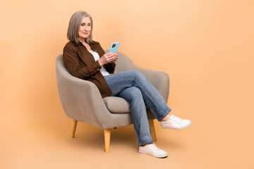 Full body size photo of sitting comfort armchair retired businesswoman browsing candidates list...