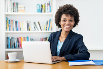 Pretty african american business trainee working at computer