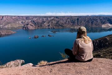 young woman with open arms in a landscape of mountains and free lake on a clear sunny day - obrazy, fototapety, plakaty