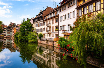 La Petite France is a picturesque “quartier“ in Strasbourg in Alsace, France. Panoramic view of colorful truss houses on the waterfront of old town channel system. Major tourist destination and sight.