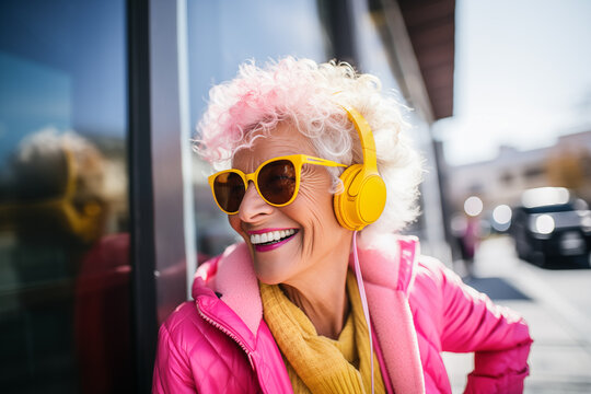 Smiling modern elderly woman listening to music with her headphones